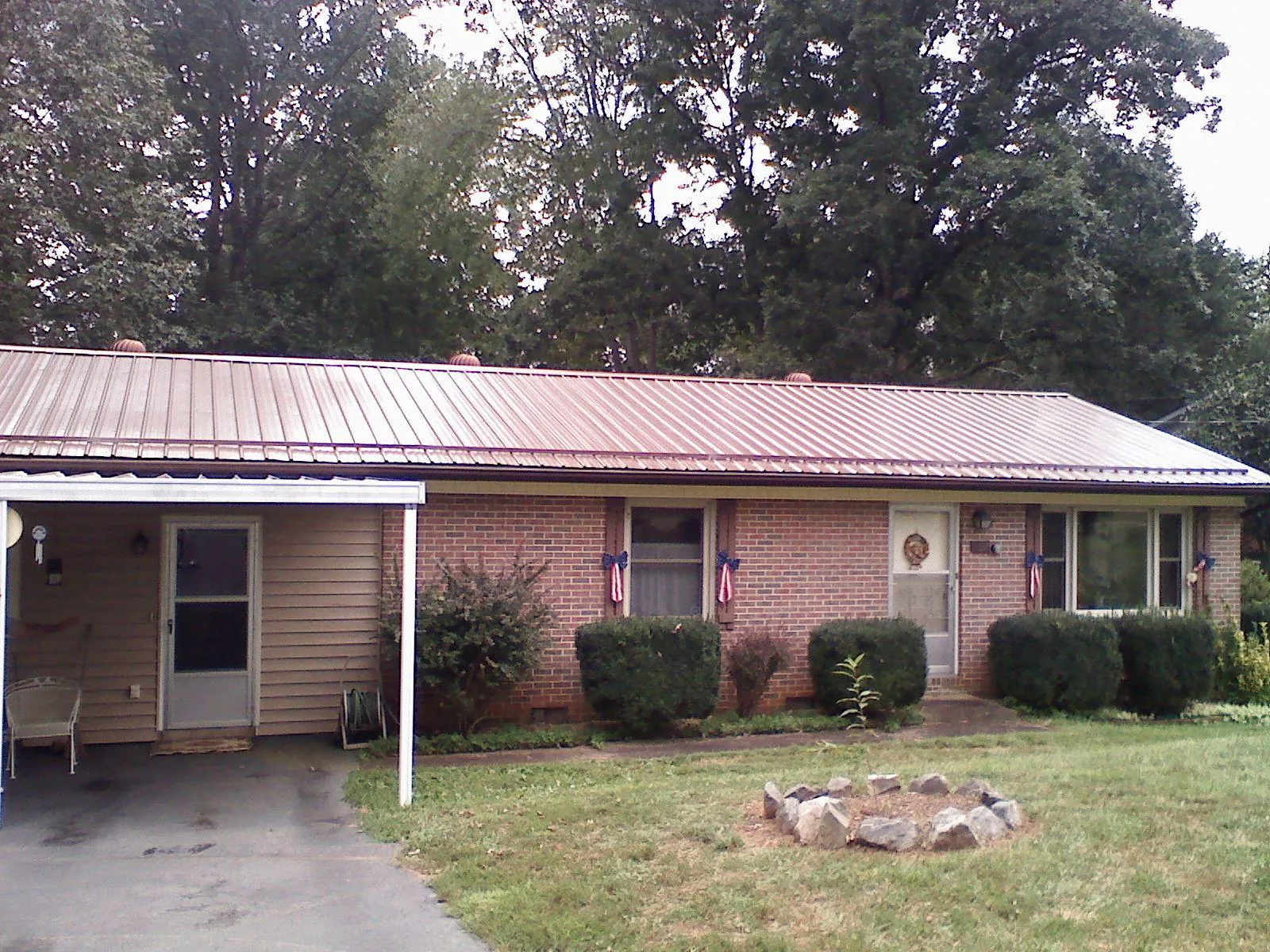 Bronze metal roof and carport on a brick ranch home — Roof Repair work by our crew in Bloomingdale